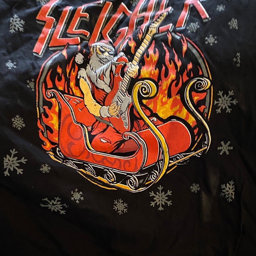 3/$15. “Sleigher” Men’s Black Graphic Tee with Santa and Guitar Design.